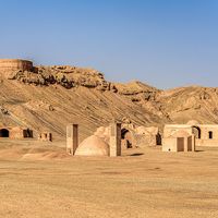 Towers of silence in a barren desert under clear blue skies. A Dakhma, also known as the Tower of Silence, is a circular, raised structure built by Zoroastrians for excarnation