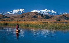 Aymara man poling a reed boat on Lake Titicaca