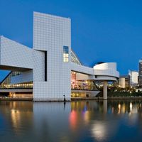 Downtown Cleveland after sunset. Rock and Roll Hall of Fame and Museum (left). Museum and hall of fame in Cleveland that celebrates the history and cultural significance of rock music