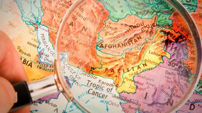 Magnifying glass focusing on Afghanistan, Pakistan and surrounding countries on world map