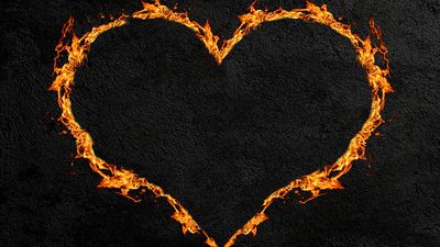 Fiery heart or heart made of flames with a dark concrete wall background. (love, Valentine's Day)