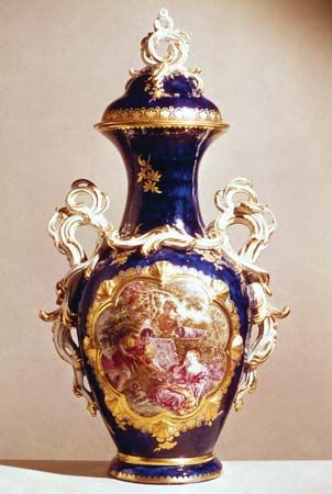 Chelsea soft-paste porcelain vase in the French Rococo style of Sèvres ware with “mazarin blue” ground and a “reserve” panel painting by John Donaldson (after François Boucher), gold anchor mark, c. 1763; in the Victoria and Albert Museum, London.