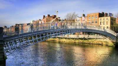 Halfpenny bridge spans the River Liffey in Dublin, Ireland. The city takes its name from the Liffey's dark waters, called dubh linn (black pool) in Irish.