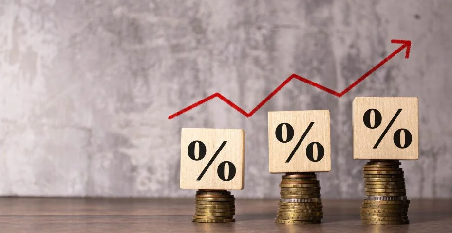 Conceito de inflação, seta vermelha do gráfico, sinal de porcentagem em um cubo de madeira com fileira de moedas na ideia para FED considerar.