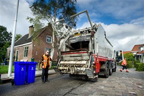 Kliko&#x27;s voor oud papier worden geleegd in vuilniswagen