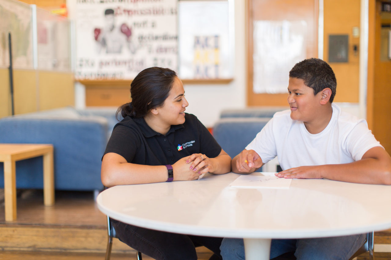 Male student talking with female site coordinator