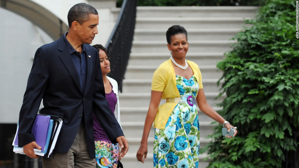 Obama has been known to wear dresses from mass retailer Talbots and accessorize them with signature pieces such as this sweater from Dear Cashmere and a belt by Sonia Rykiel, worn in July 2009, &lt;a href=&quot;http://mrs-o.com/newdata/2009/7/5/bon-voyage.html&quot; target=&quot;_blank&quot;&gt;according to Mrs. O&lt;/a&gt;.