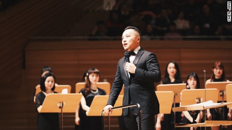 Rainbow Chamber Singers conductor Jin Chengzhi speaks to the audience at the choir&#39;s Spring Festival concert.