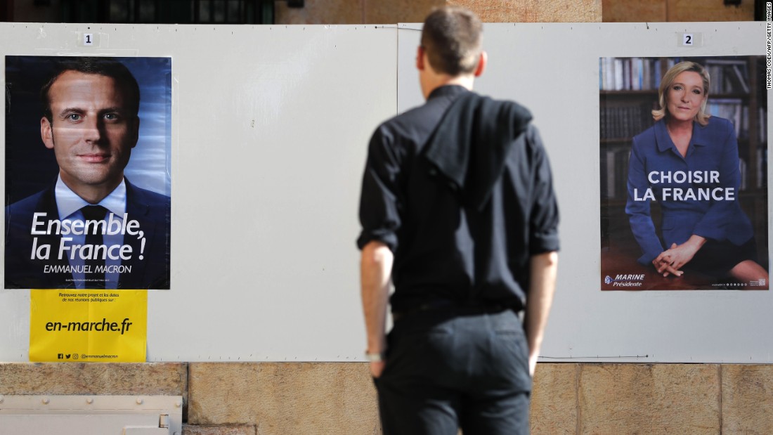 A man looks at election posters of the French presidential candidates, Emmanuel Macron and Marine Le Pen, at the French consulate in Jerusalem, on May 7. French citizens worldwide are casting their votes during the second round of the country&#39;s presidential vote.  