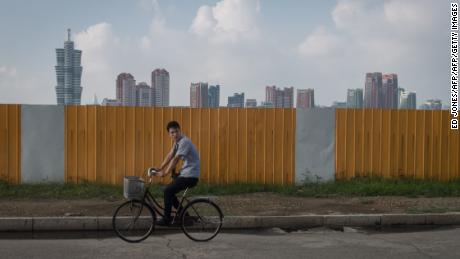 TOPSHOT - A photo taken on July 24, 2017 shows a man cycling along a street before the skyline of Pyongyang. / AFP PHOTO / Ed JONES        (Photo credit should read ED JONES/AFP/Getty Images)