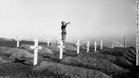 On December 13, 1950 during memorial services at the First Marine cemetery in Hungnam, Korea, Corporal Charles Price sounds &quot;Taps&quot; over the graves of fallen U.S. Marines following the division&#39;s heroic break-out from Chosin Reservoir. (Photo by © CORBIS/Corbis via Getty Images)