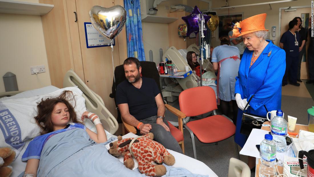 Elizabeth speaks to Evie Mills, 14, at a hospital in Manchester, England, in May 2017. Evie was injured in a bombing that took place as people left an Ariana Grande concert.