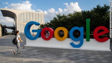 A woman and her child play on a Google sign at the World Artificial Intelligence Conference (WAIC) in Shanghai on September 26, 2018. (Photo by Johannes EISELE / AFP)        (Photo credit should read JOHANNES EISELE/AFP/Getty Images)