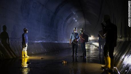 Hong Kong Drainage Services Department employees stand inside the tunnel, near the neighborhood of Tai Hang.&#39;