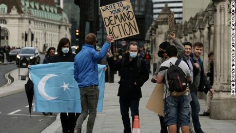 LONDON, ENGLAND - OCTOBER 08: People hold placards and an Uighur flag during a protest in support of Uighur people over ongoing human rights violations in China&#39;s Xinjiang autonomous region, home to the ethnic Uighur community, in London, United Kingdom on October 08, 2020. (Photo by Hasan Esen/Anadolu Agency via Getty Images)