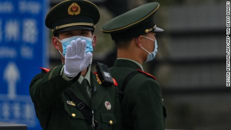 A Chinese paramilitary policeman gestures on the promenade of the Bund along the Huangpu River in Shanghai on April 16, 2021. (Photo by Hector RETAMAL / AFP) (Photo by HECTOR RETAMAL/AFP via Getty Images)