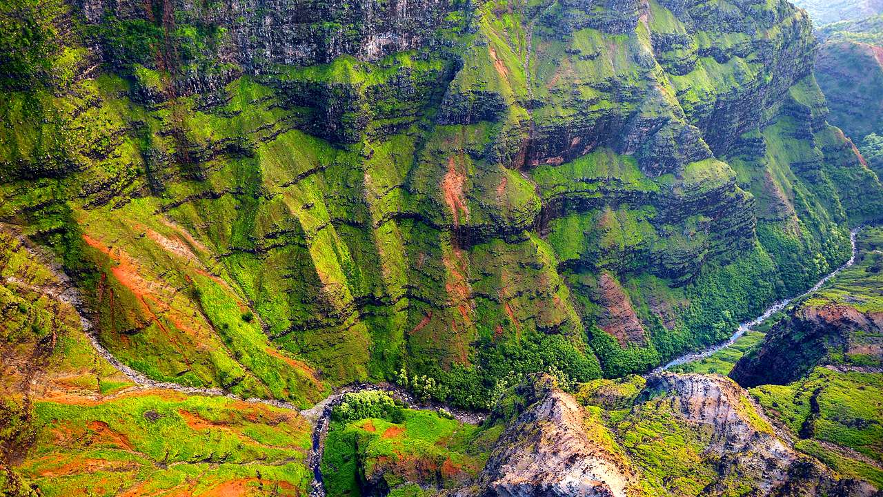 View from above of rock outcrops and canyons with a stream running across the bottom