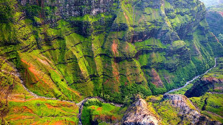 View from above of rock outcrops and canyons with a stream running across the bottom