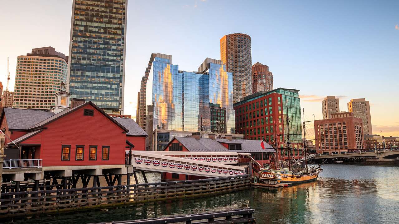 A boat docked in a pier with buildings and skyscrapers in the background