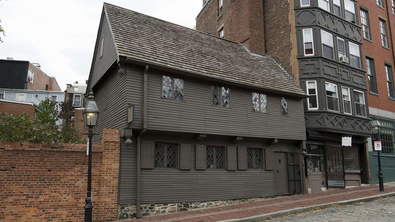 A small wooden home along a bricked road on a gloomy day