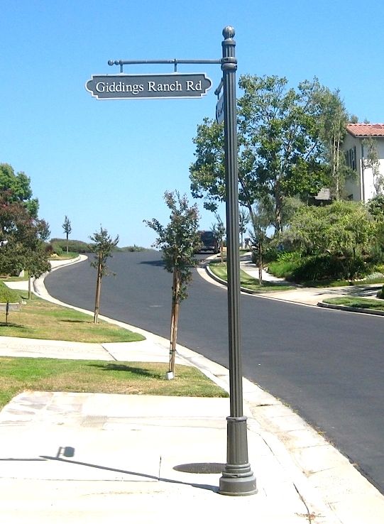 H17006 - Street Name Sign with Frame, hung from a Straight Horizontal Bar mounted on an Aluminum Post with Decorative Base and Finial