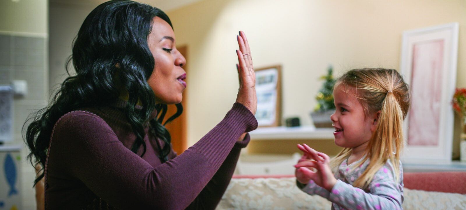 A CASA mentor high-fiving a young girl.