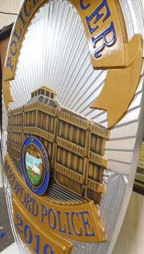 M7458 - Close-up of Metallic Silver and Gold Painted Carved  Wall Plaque featuring the badge of  a Police Officer in Medford , Oregon.