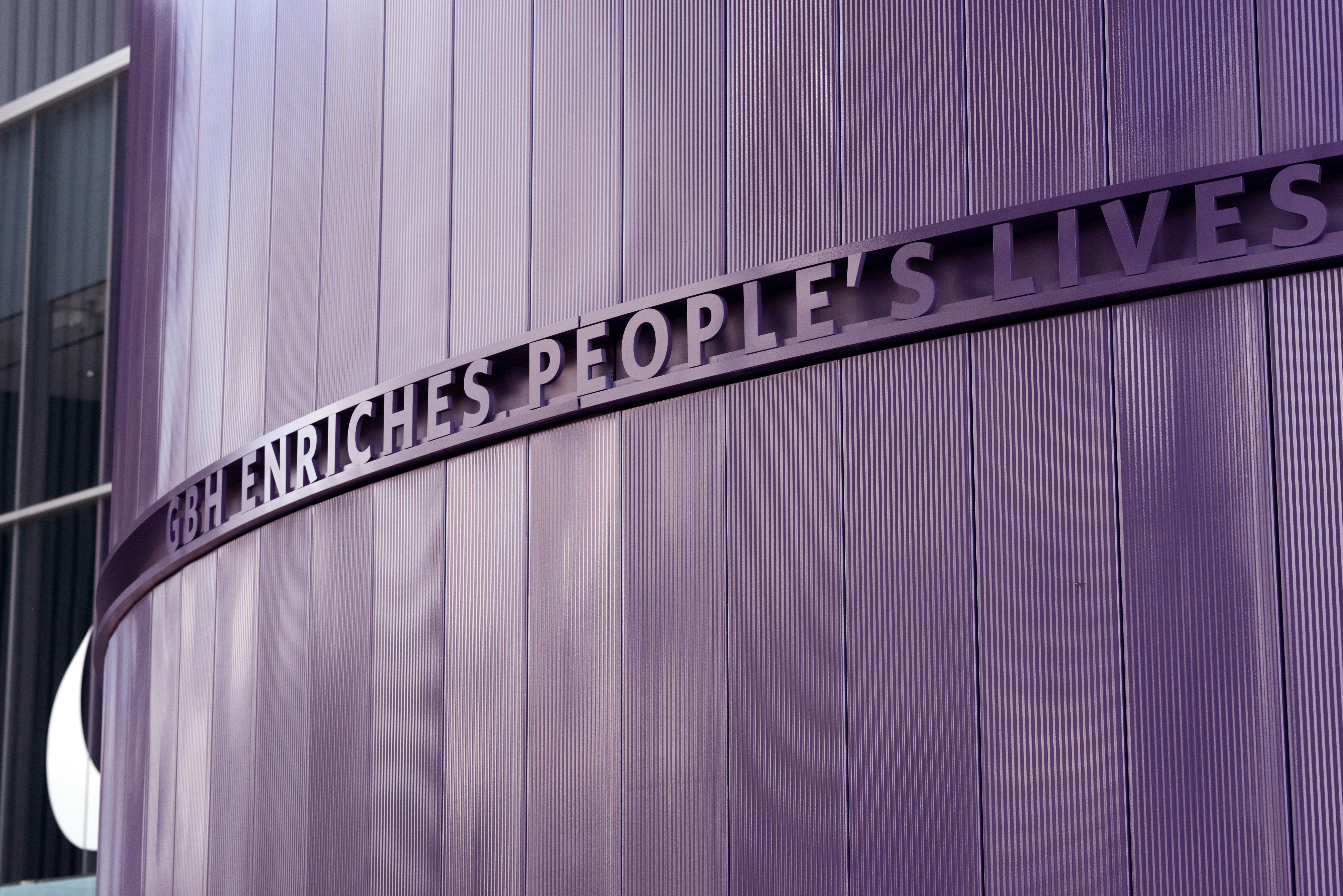 The wall outside the GBH building, which reads "GBH Enriches People's Lives"