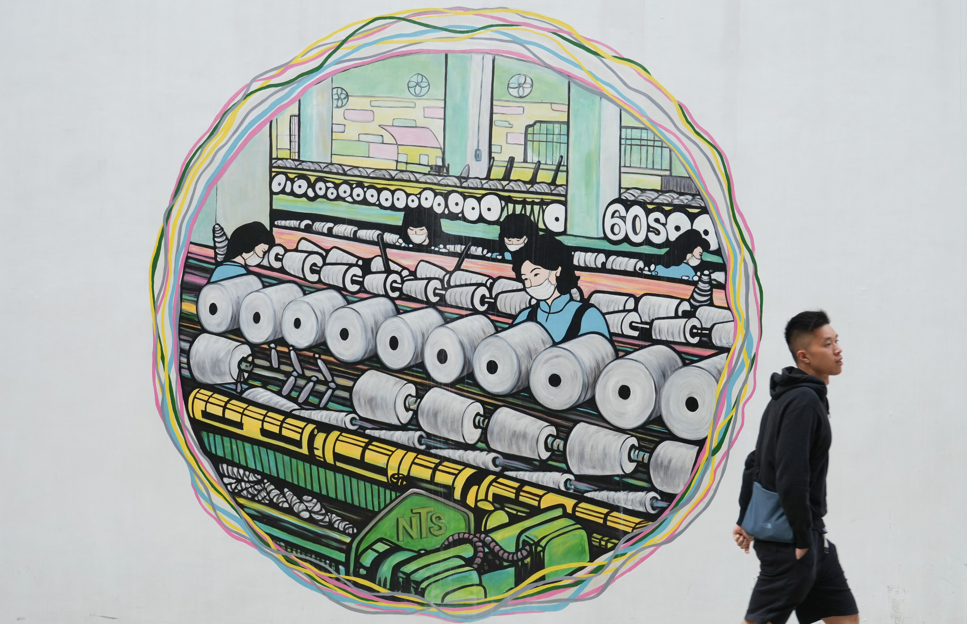 A man walks past graffiti created as a collaboration between the Hong Kong Youth Arts Foundation and six local artists at The Mills in Tsuen Wan on January 3. Photo: Sam Tsang