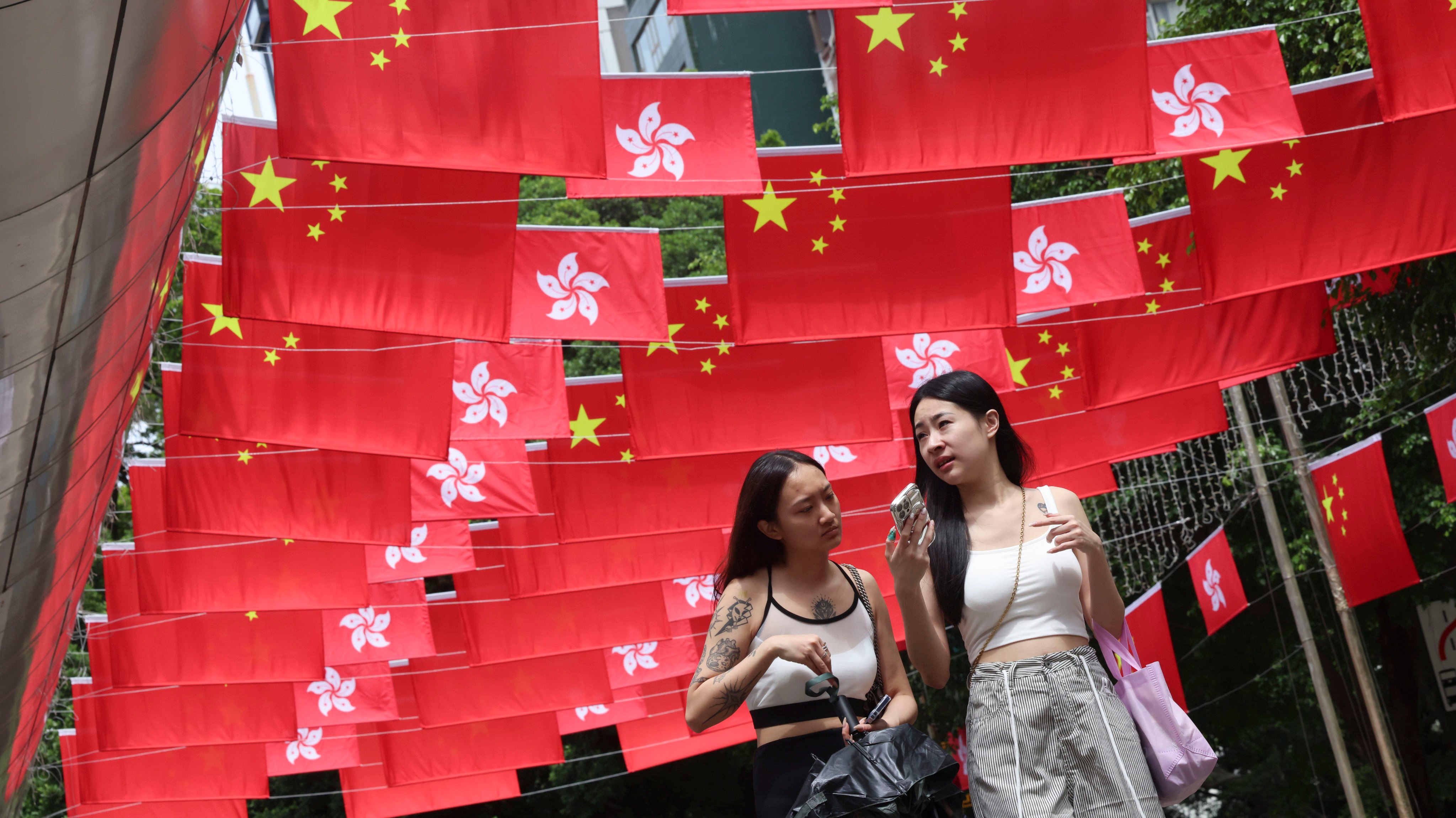 People walk along a street in Tsim Sha Tsui decorated with national and Hong Kong Special Administrative Region flags on September 25 to celebrate the 75th anniversary of the founding of the People’s Republic of China on October 1. Photo: Jelly Tse