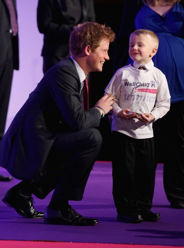 The Duke of Sussex hold a child at the wellchild awards