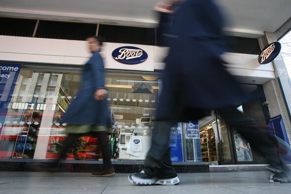 Pedestrians pass by a Boots pharmacy in London, U.K., Tuesda