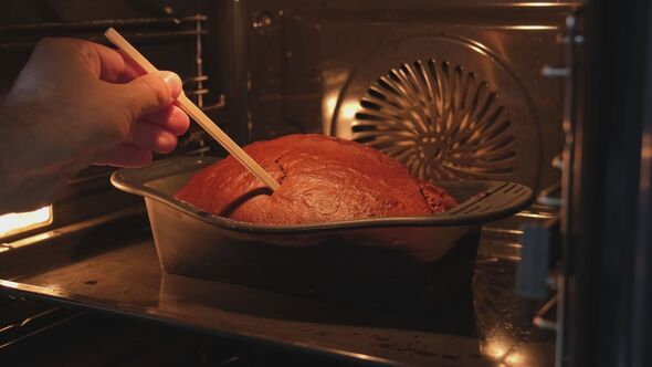 Male Checking Banana Bread Baked in Electric Oven using Wooden Skewer