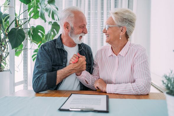 Happy senior couple signing an agreement.