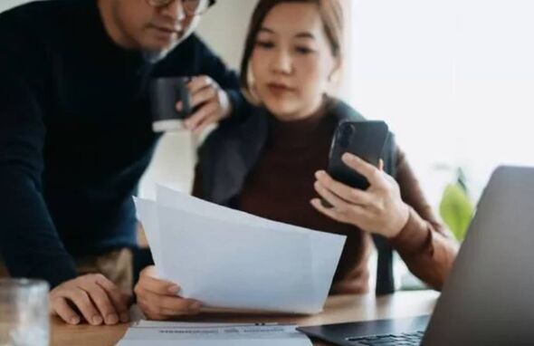 Man and woman look concerned over bills