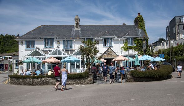 St Mawes, Cornwall, England, UK, Customers arriving and leaving the Rising Sun at St Mawes village center in southern Cornwall.