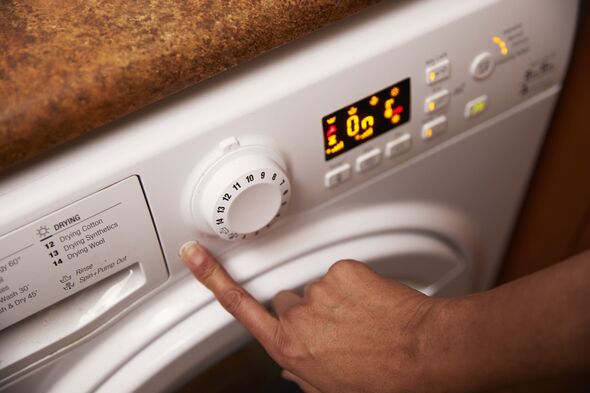 Woman operating washing machine at home