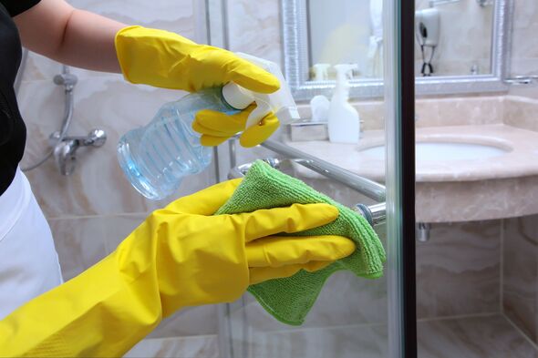 Woman cleaning shower screen