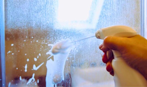 Picture of someone cleaning a dirty shower screen 