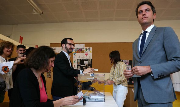 France's Prime Minister Gabriel Attal holding his ballot