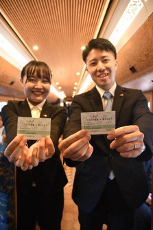 New employees of Kyushu Railway Co. (JR Kyushu) smile as they hold their "entrance ticket" letters of appointment at JR Yoshizuka Station in Fukuoka's Hakata Ward on Oct. 1, 2024. (Mainichi/Tomohiro Shimohara)