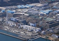 This aerial photo taken from a Mainichi Shimbun helicopter shows, from right, No. 1 through 4 reactors and wastewater tanks, background, at Tokyo Electric Power Company Holdings Inc.'s Fukushima Daiichi Nuclear Power Station in Okuma, Fukushima Prefecture, on Feb. 13, 2021. (Mainichi/Koichiro Tezuka)