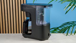 A black Instant Infusion Brew 12-Cup drip coffee maker with a removable water reservoir, glass carafe and reusable coffee filter