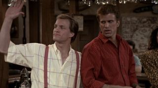 Woody Harrelson waving while Ted Danson looks annoyed on Cheers