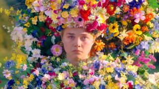 Florence Pugh at the end of Midsommar looking sadly at her boyfriend, Christian, while wearing flowers for the final ceremony.