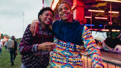 Young couple are laughing and talking as they walk around a date at a carnival