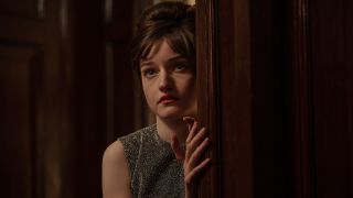 Julia Garner looking behind a door in Apartment 7A