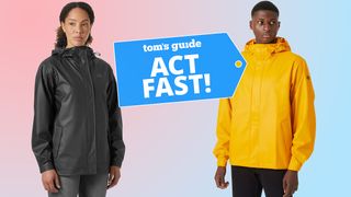 Two models standing against a colorful background wearing a yellow and black Helly Hansen rain jacket with a Tom's Guide deals badge in between them