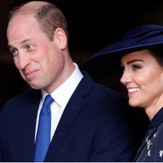 Prince William smirks while wearing a blue tie and suit and Kate Middleton smiles in a navy dress and matching hat at the 2023 Commonwealth Day Service at Westminster Abbey on March 13, 2023