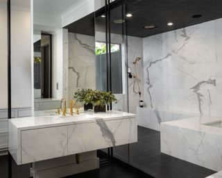 bathroom with marble tiled walls and black tiled ceiling and floor